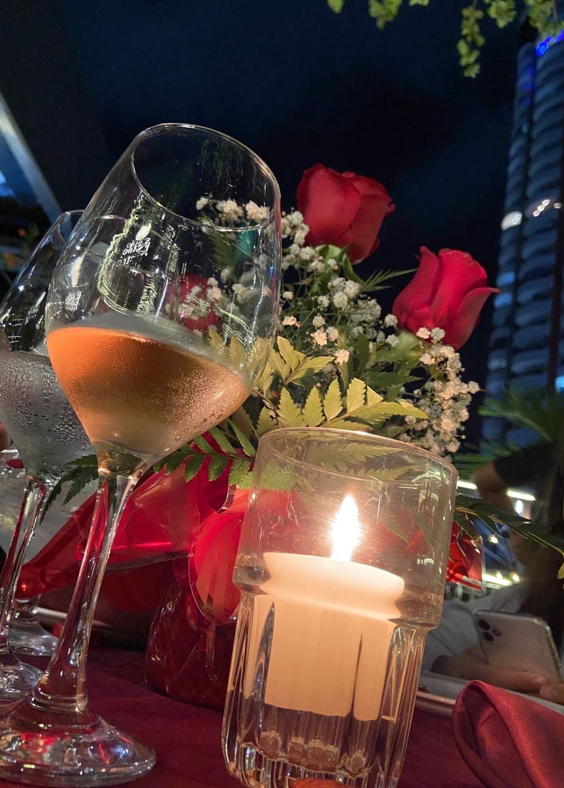 Taça de vinho com rosas e vela